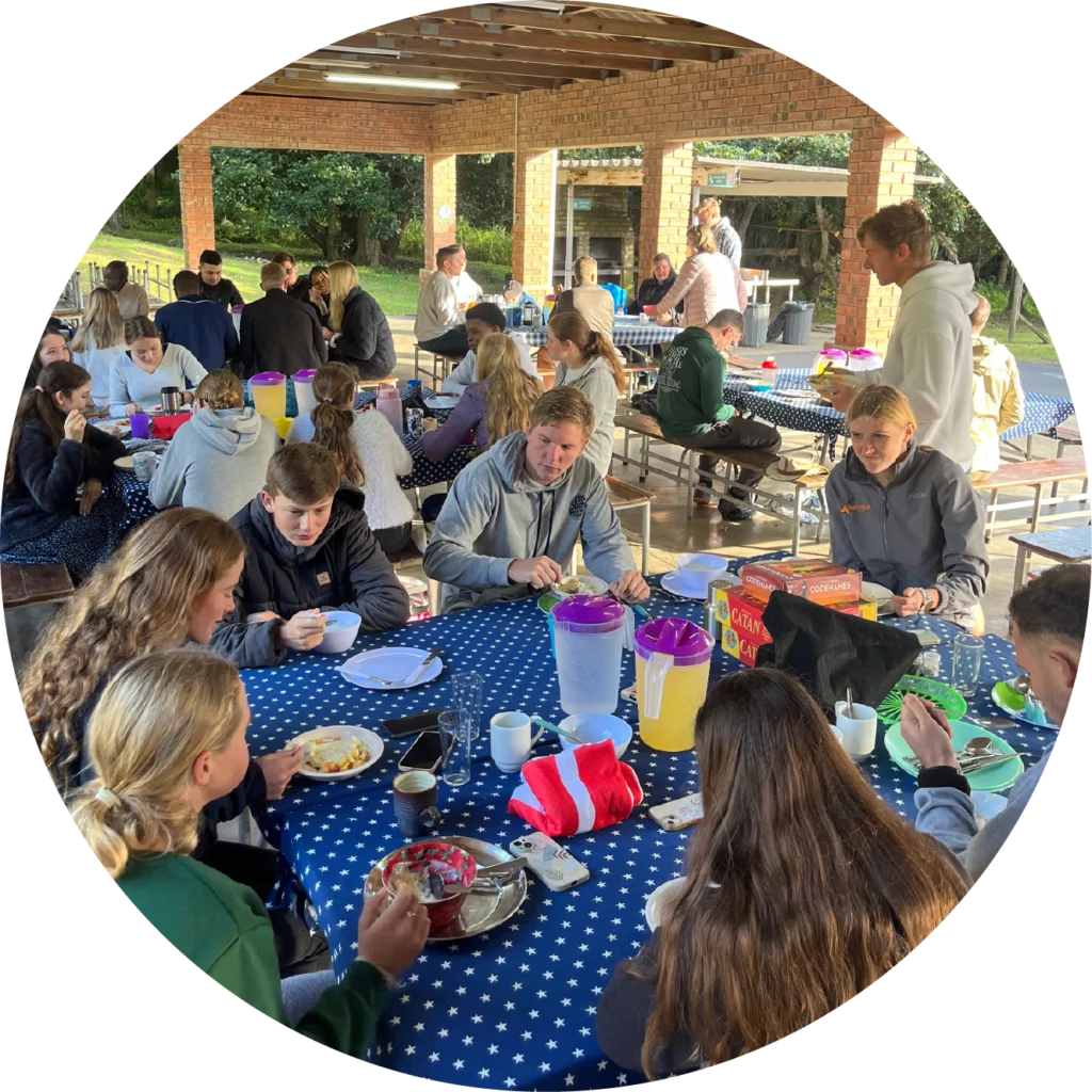 Campers enjoying breakfast together in the open-air dining hall at Camp Anerley.