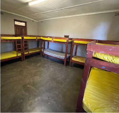 Dormitory room at Camp Anerley with wooden bunk beds and yellow mattresses, prepared for campers.