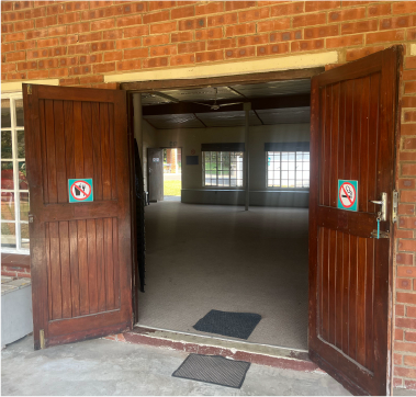 Open double doors leading into a large hall at Camp Anerley, used for meetings, gatherings, or indoor activities.