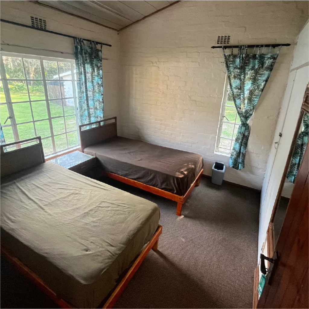 Cozy private room with two single beds and garden views at Camp Anerley.
