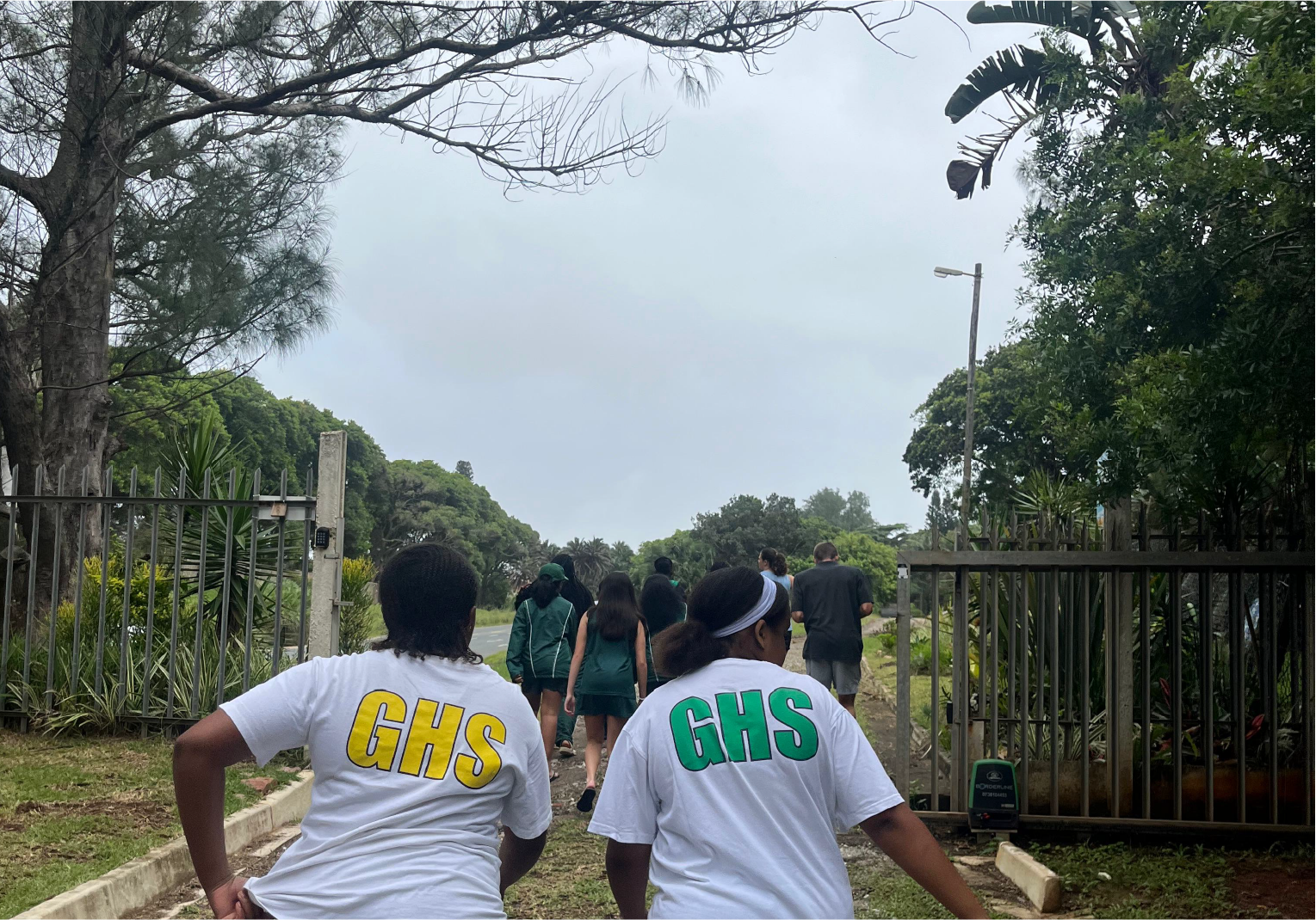 Students from GHS walking together during a camp outing at Camp Anerley surrounded by trees and greenery.