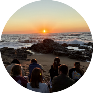 Camp Anerley group sitting on the beach watching the sunrise over the ocean.
